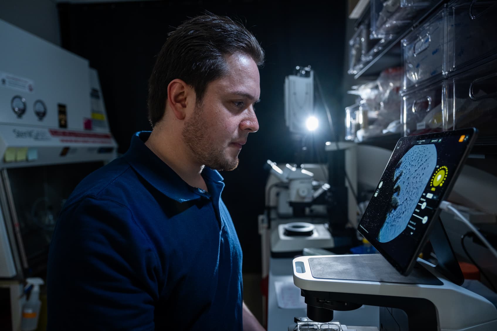 Andrés Tibabuzo examining a sample with a digital microscope