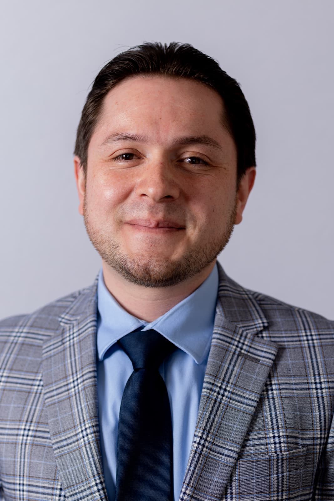 Andrés Tibabuzo wearing a suit jacket and tie